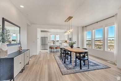 Dining space featuring light wood-style flooring, recessed lighting, and a chandelier