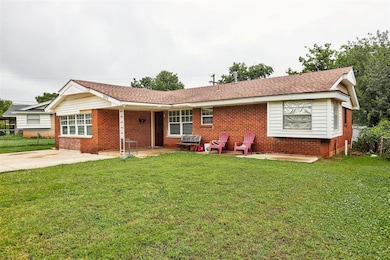 Ranch-style house with brick siding, a shingled roof, and a patio area