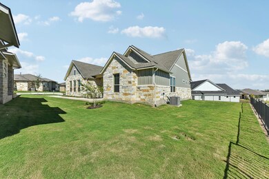 View of side of home featuring stone siding, a lawn, board and batten siding, and roof with shingles