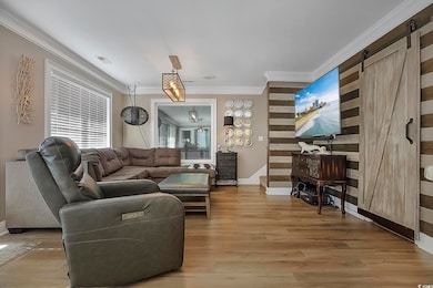 Living room with a barn door, visible vents, stair