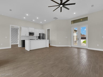 Unfurnished living room featuring ceiling fan, woo