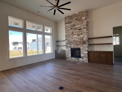 Unfurnished living room with dark wood finished floors, a fireplace, ceiling fan, and a high ceiling