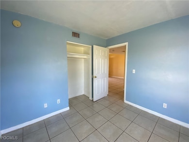 Unfurnished bedroom with tile patterned floors and a closet