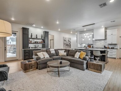 Living room with recessed lighting, a chandelier, light wood-style floors, and a fireplace