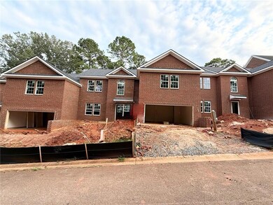 View of front of property with a garage, brick siding, and driveway