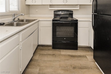 Kitchen with light countertops, a sink, white cabi