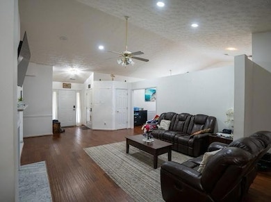 Living room with vaulted ceiling, a ceiling fan, w