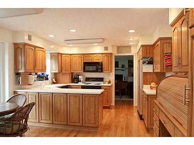 Kitchen. Hickory cabinetry, solid surface counters, hardwood floors and built-in roll top desk