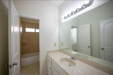 Full bathroom with tiled shower / bath combo, vanity, toilet, and tile patterned floors
