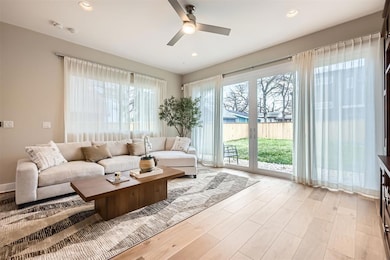 Living area with a ceiling fan, light wood-type f