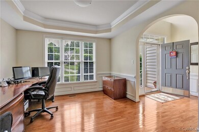 Formal living room (or office) with arched openings, tray ceiling, wood moldings