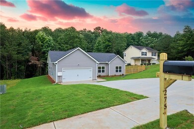 View of front of property featuring a front lawn, driveway, and a garage