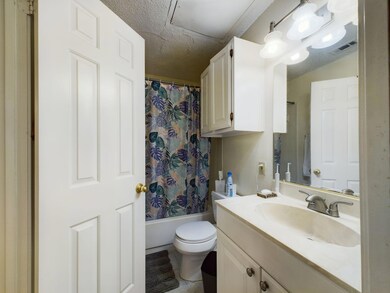 Full bath with a textured ceiling, toilet, visibl