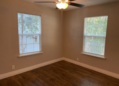 Unfurnished room featuring plenty of natural light and baseboards