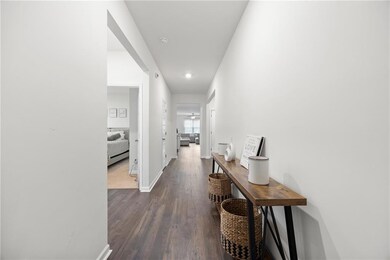 Corridor featuring dark wood-style floors, baseboa