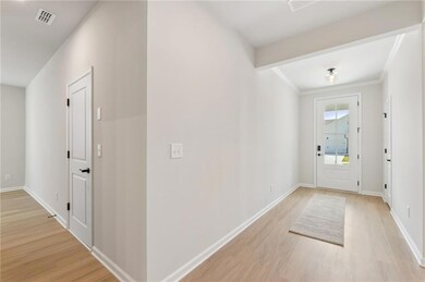 Entryway featuring light wood-style flooring and crown molding