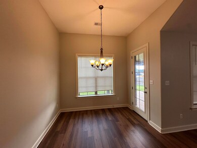 Unfurnished dining area with dark wood-style flooring and a chandelier