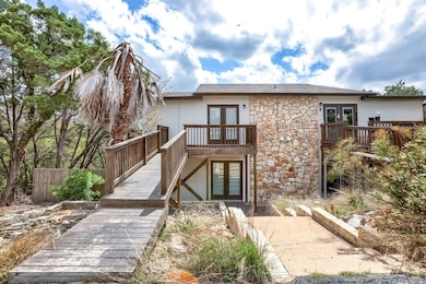 Rear view of property with french doors, stone siding, and stairs