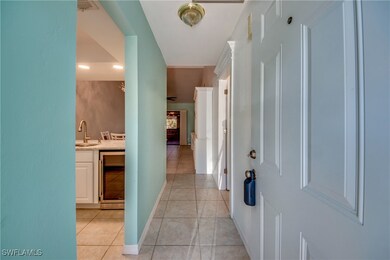 Corridor with a sink, wine cooler, light tile patt