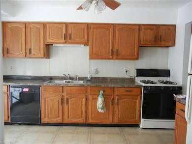 Kitchen with stove and refrigerator, new disposal.