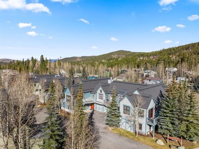 Aerial perspective of suburban area with a mountain backdrop and a heavily wooded area