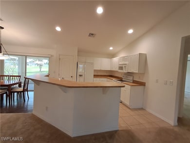 Kitchen with white appliances, white cabinets, rec