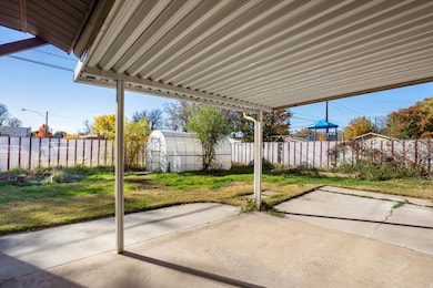 Fenced backyard featuring an outbuilding and a patio