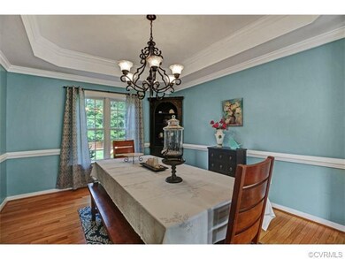 Formal dining room has tray ceiling, wood floors &