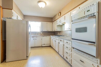 Kitchen featuring white appliances, backsplash, si