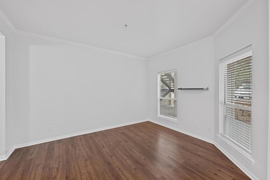 Empty room featuring dark wood-style floors, base