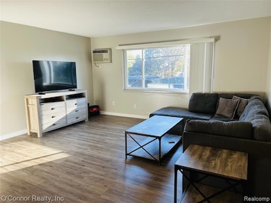 Back of property with a metal roof, a lawn, and brick siding