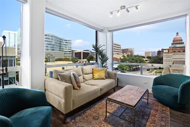 Sitting room with a view of city and wood finished floors