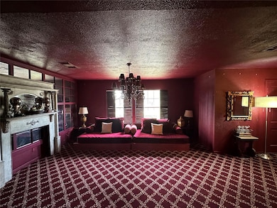 Living room with carpet flooring, a textured ceili