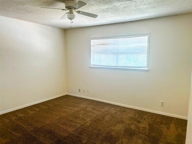 Spare room with dark colored carpet, ceiling fan,