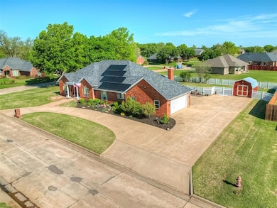 View of front of home featuring a garage, brick siding, driveway, solar panels, and a residential view