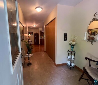 Hall with tile patterned flooring and baseboards