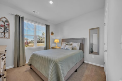 Bedroom with light carpet, baseboards, and visible