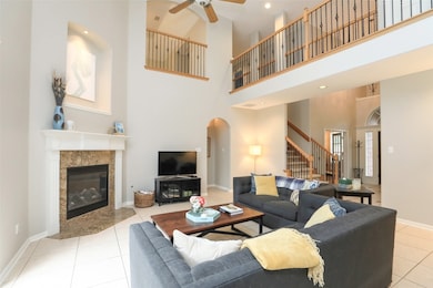 A lovely mantled fireplace grants an intimate feel to the grand living room, with French doors flowing out to the backyard oasis.