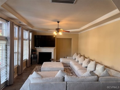 Living area featuring ornamental molding, a raised