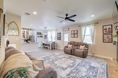Living room with ceiling fan, light wood finished