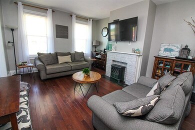 Living room with large windows and newer hardwood 