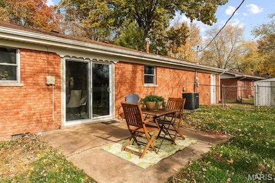 Rear view of house featuring a patio area and brick siding