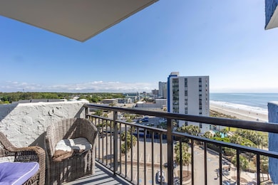 Balcony featuring a water view and a beach view