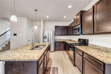 Kitchen featuring dark brown cabinetry, stainless 