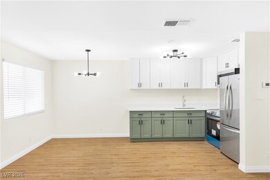 Kitchen with light wood finished floors, stainless
