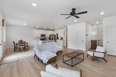 Living room with recessed lighting, light wood finished floors, and a ceiling fan