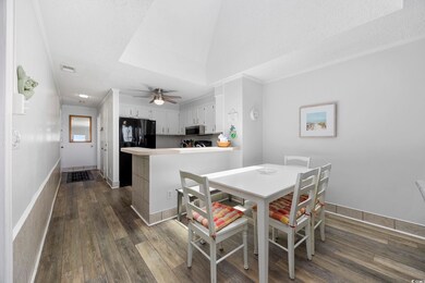 Dining room featuring dark wood-type flooring, a ceiling fan, a textured ceiling, and baseboards