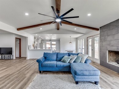 Living room with vaulted ceiling with beams, light