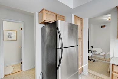 Kitchen with light stone counters, light tile pat