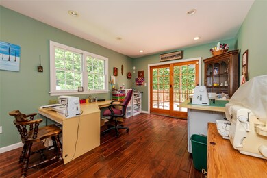 Office with dark wood finished floors and recessed lighting